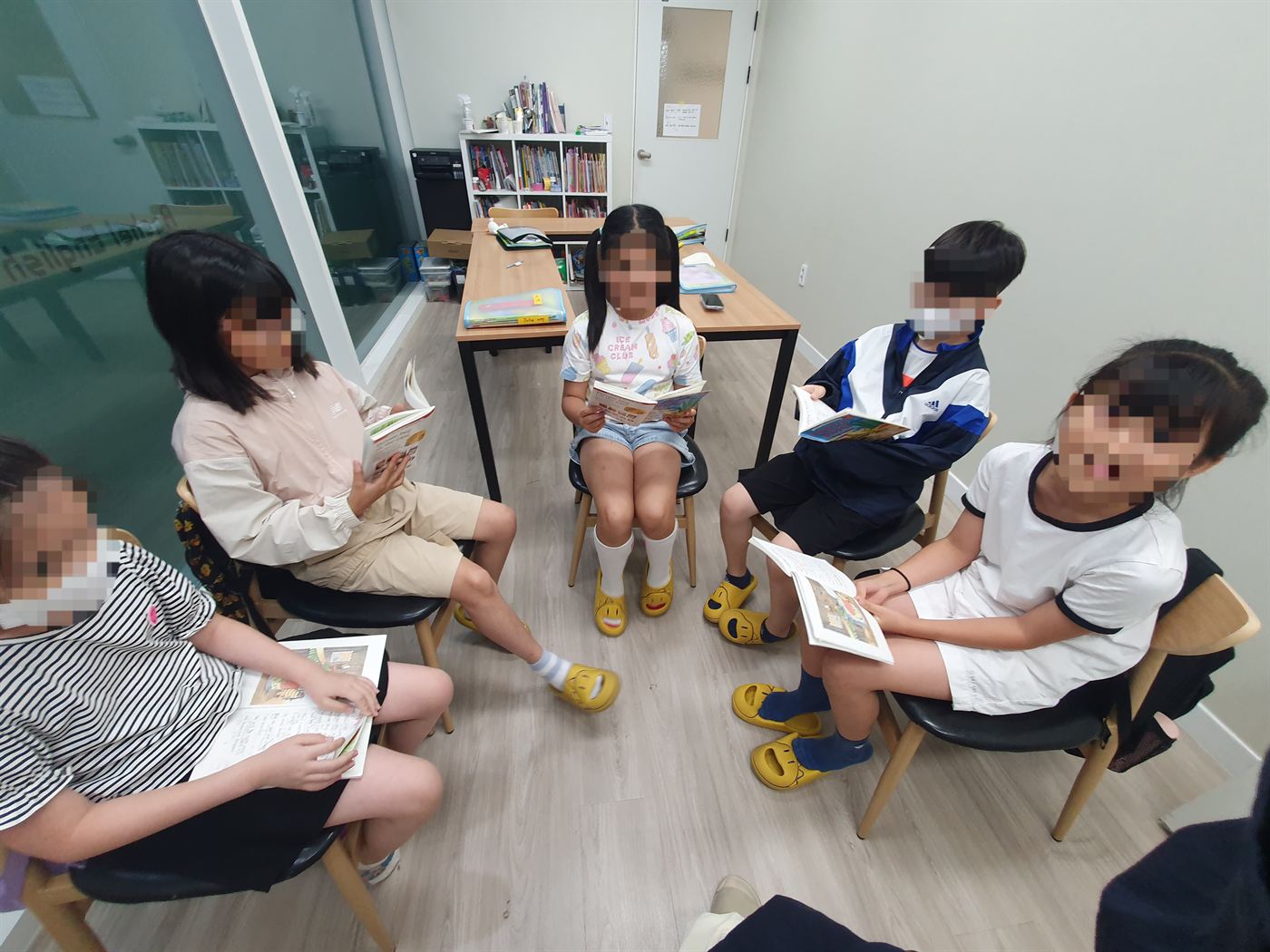 레이첼영어 초등부 학생들이 둥글게 둘러앉아 영어 원서를 읽는 모습